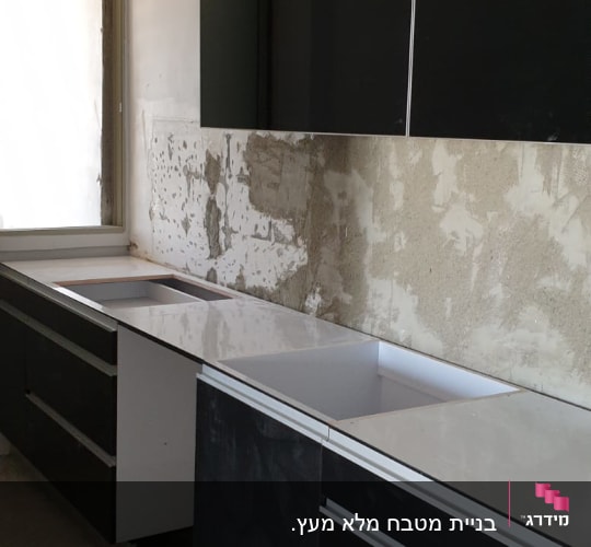 ארונות מטבח שחורים עם משטח עבודה לבן